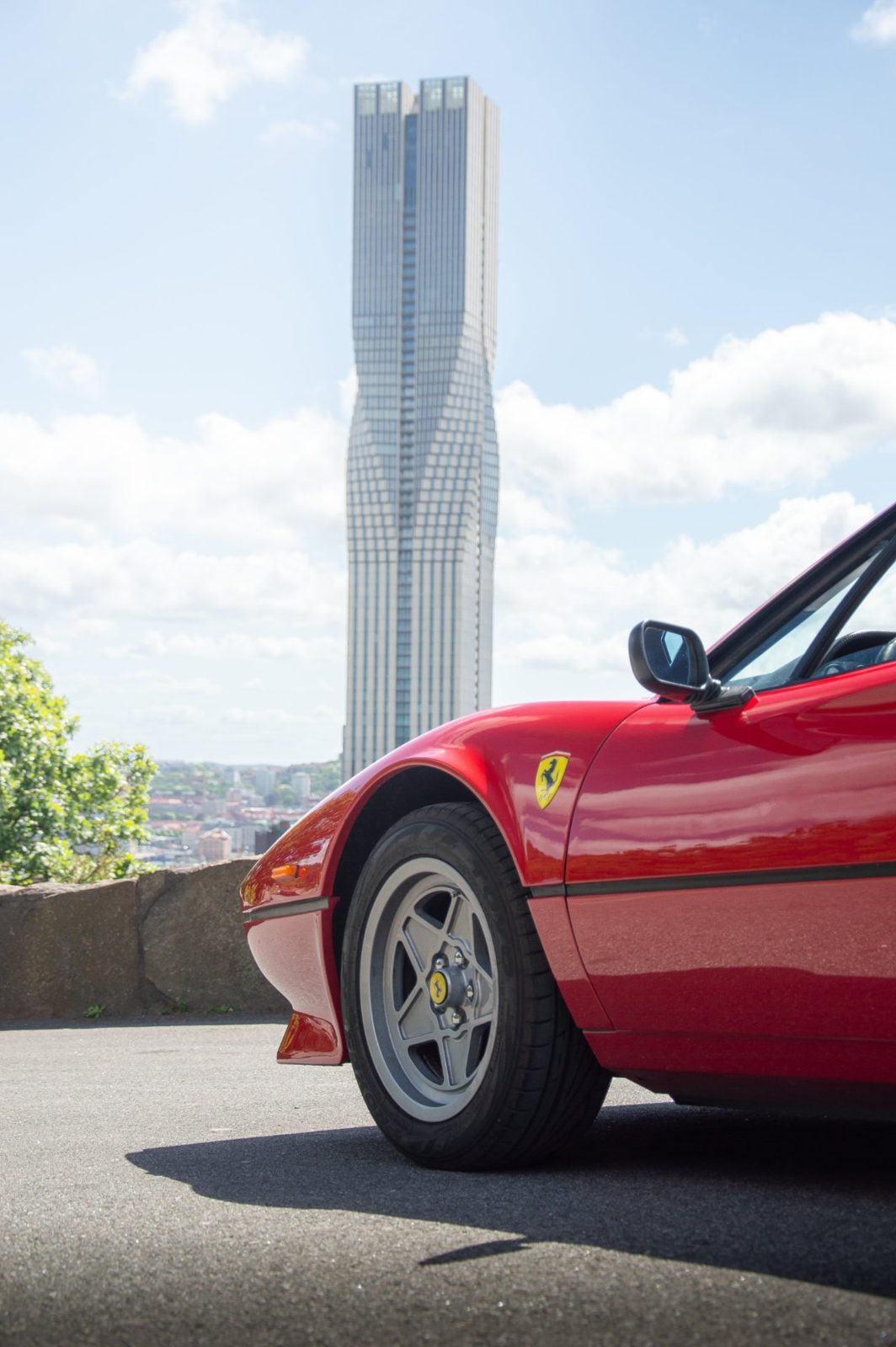 Röd Ferrari 308 framför en skyskrapa
